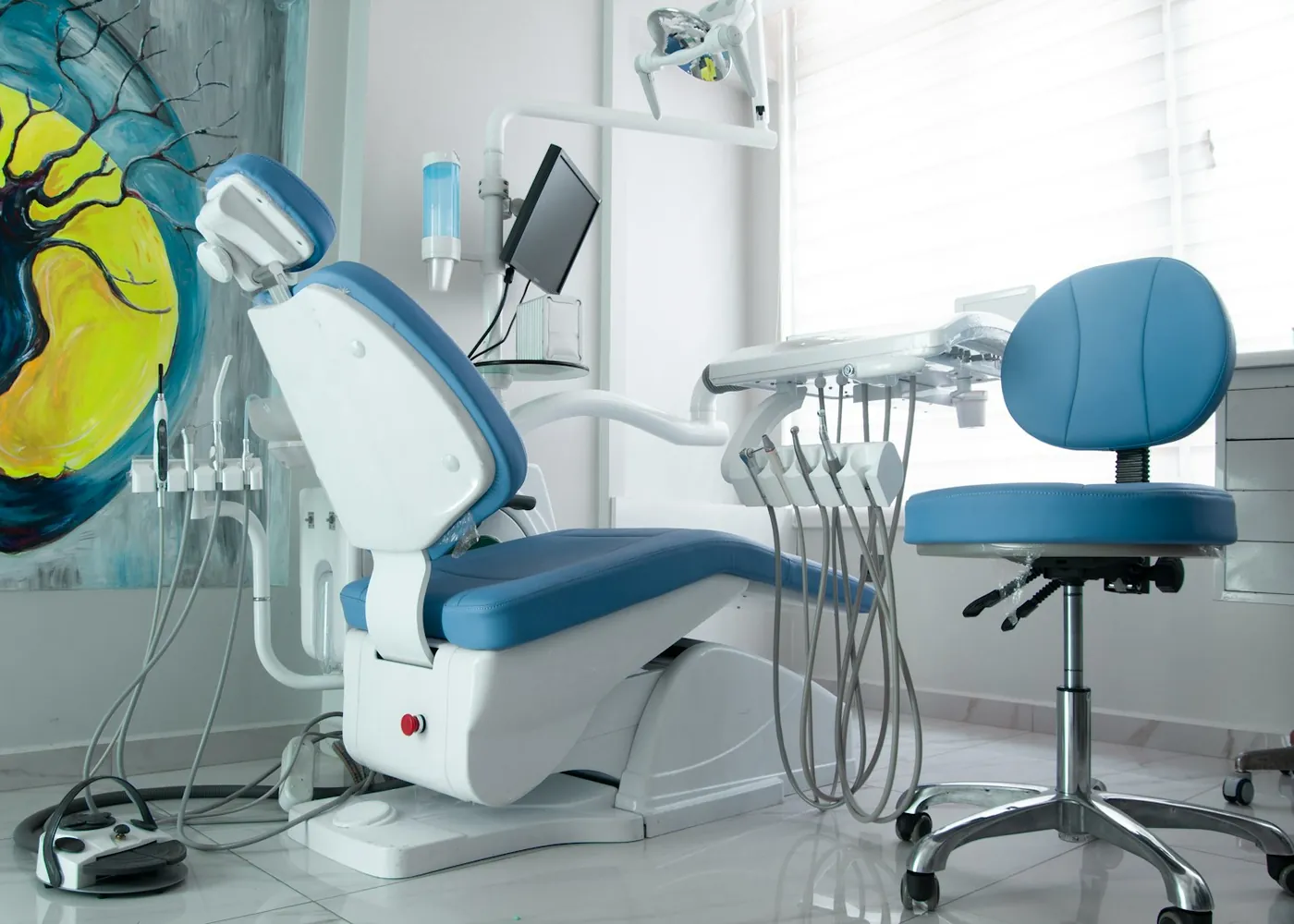 A treatment room with a blue chair and a painting